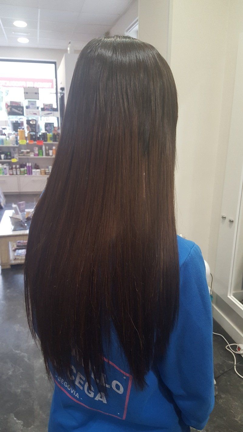 Una mujer con cabello largo y oscuro lleva una sudadera azul.