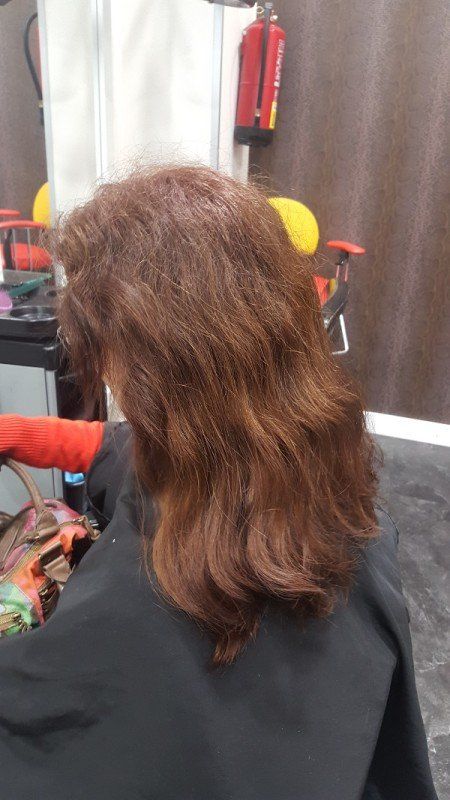 Una mujer se está secando el cabello en un salón.