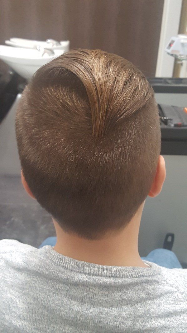 Un niño pequeño se está cortando el pelo en una barbería.