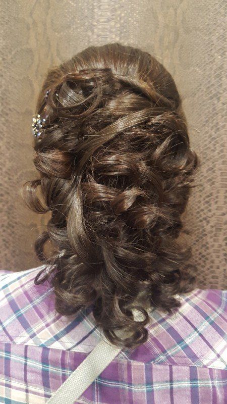 Una mujer lleva una camisa a cuadros y tiene el pelo recogido en un moño.