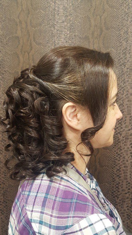 Una mujer lleva una camisa a cuadros y tiene el cabello recogido en una cola de caballo.