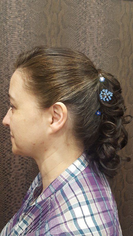 Una mujer con una camisa a cuadros lleva el pelo recogido en una cola de caballo.