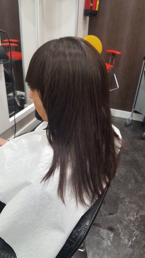 Una mujer se está cortando el pelo en una peluquería.