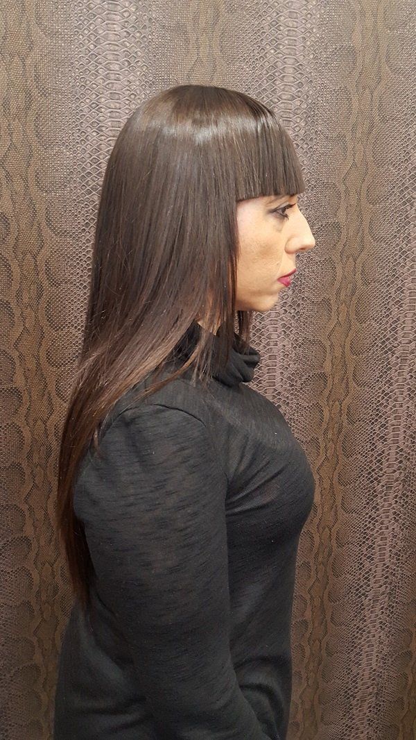 Una mujer con pelo largo y flequillo lleva un suéter de cuello alto negro.