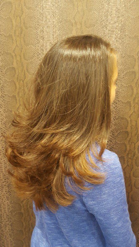 Una joven con cabello largo y castaño lleva un suéter azul.