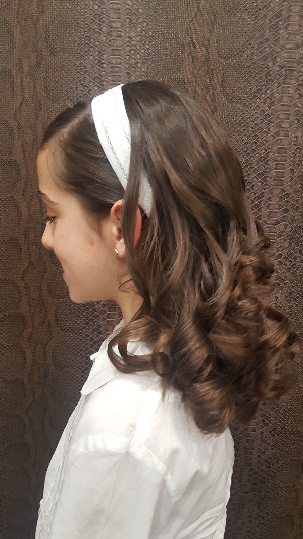 Una niña lleva una diadema blanca en el pelo.
