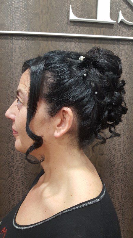 Una mujer lleva el pelo recogido en un moño con perlas.