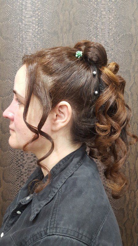 La mujer lleva una camisa negra y tiene el cabello recogido en una cola de caballo.