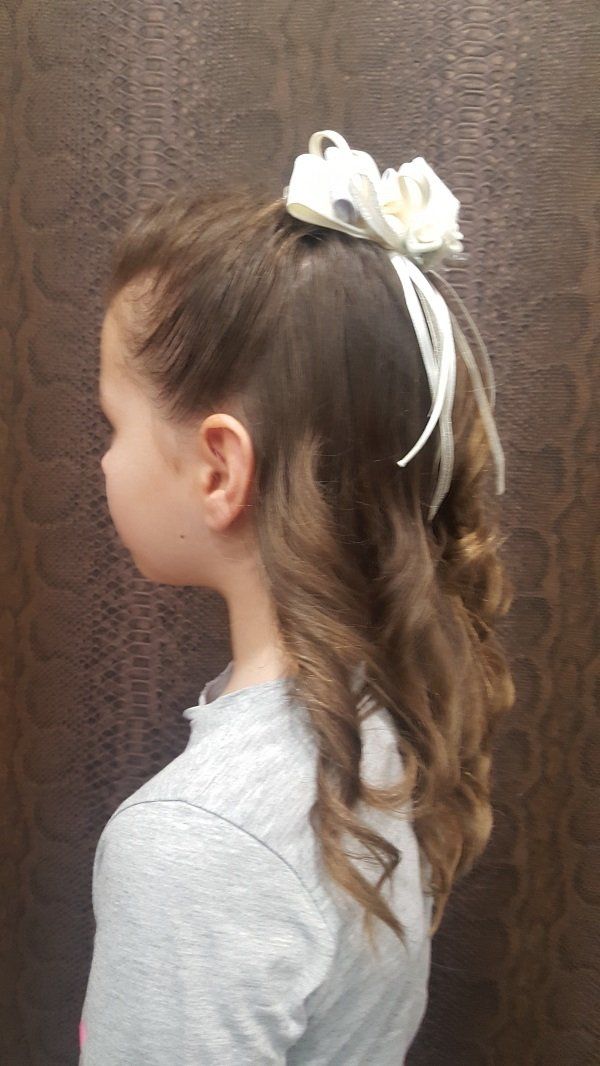 Una niña lleva una diadema con una flor en el pelo.