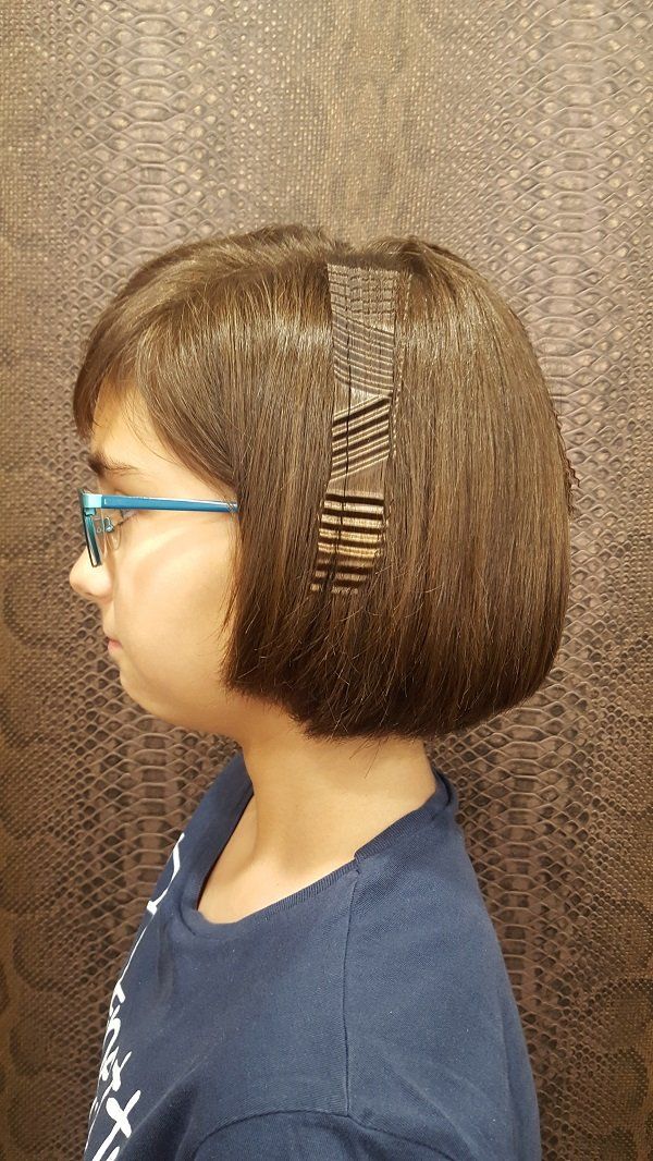 Una niña que lleva gafas y una diadema con horquillas en el pelo.