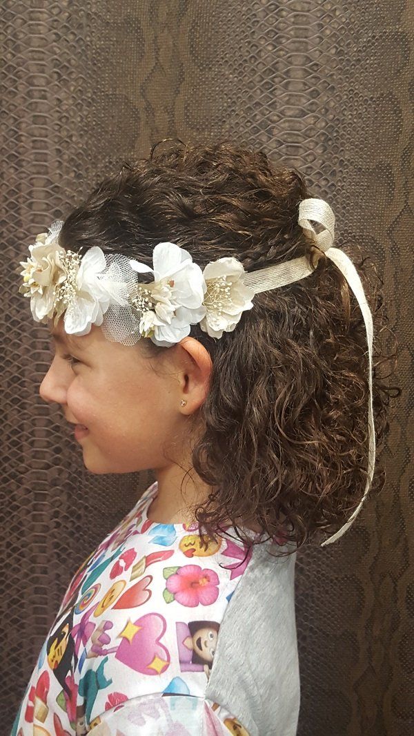 Una niña lleva una corona de flores en el pelo.