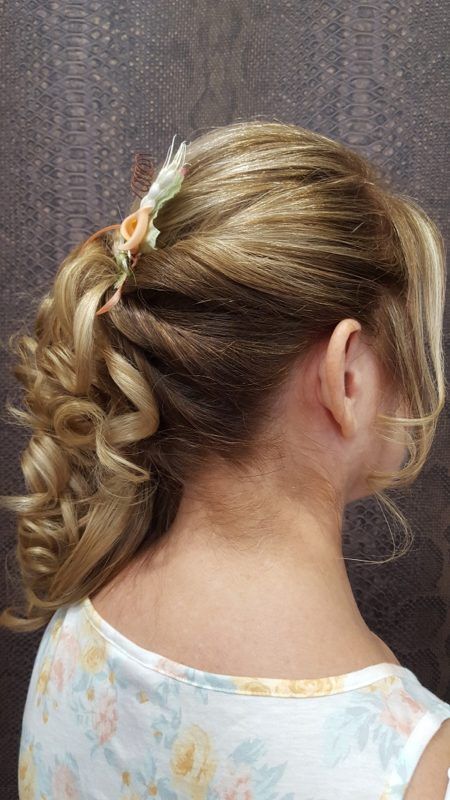 Una mujer lleva el pelo recogido en un moño con una flor en él.