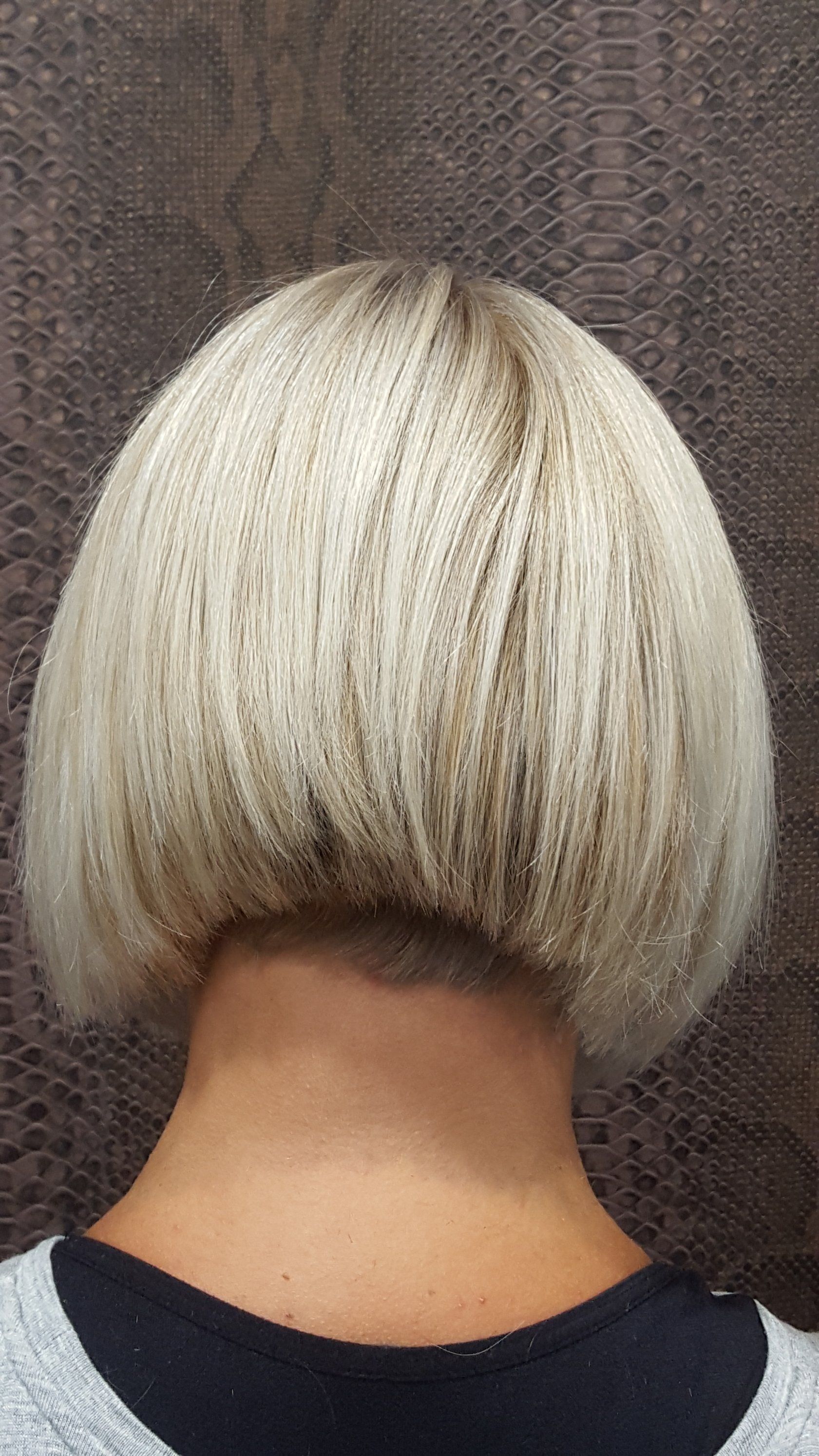 La parte posterior de la cabeza de una mujer con cabello rubio corto.