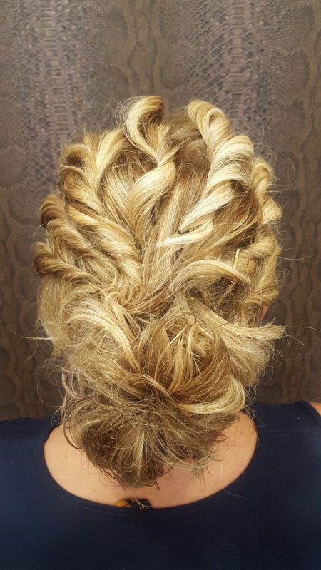 La parte posterior de la cabeza de una mujer con el cabello recogido en un moño desordenado.