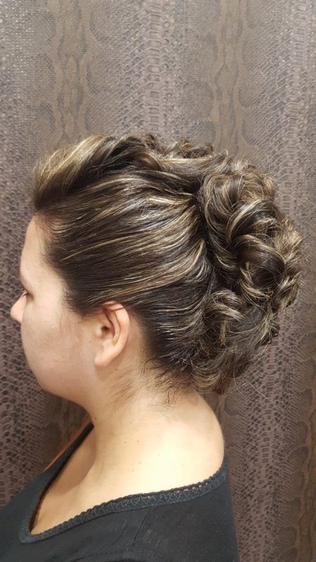 Una mujer con el pelo recogido en un moño lleva una camisa negra.