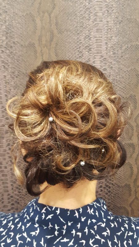 La parte posterior de la cabeza de una mujer con el pelo recogido en un moño y perlas.