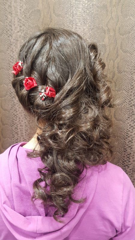 Una mujer con una sudadera con capucha morada lleva el pelo recogido mitad arriba y mitad suelto.