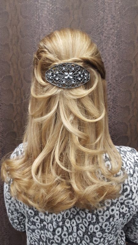 La parte posterior de la cabeza de una mujer con el cabello recogido mitad arriba y mitad abajo.