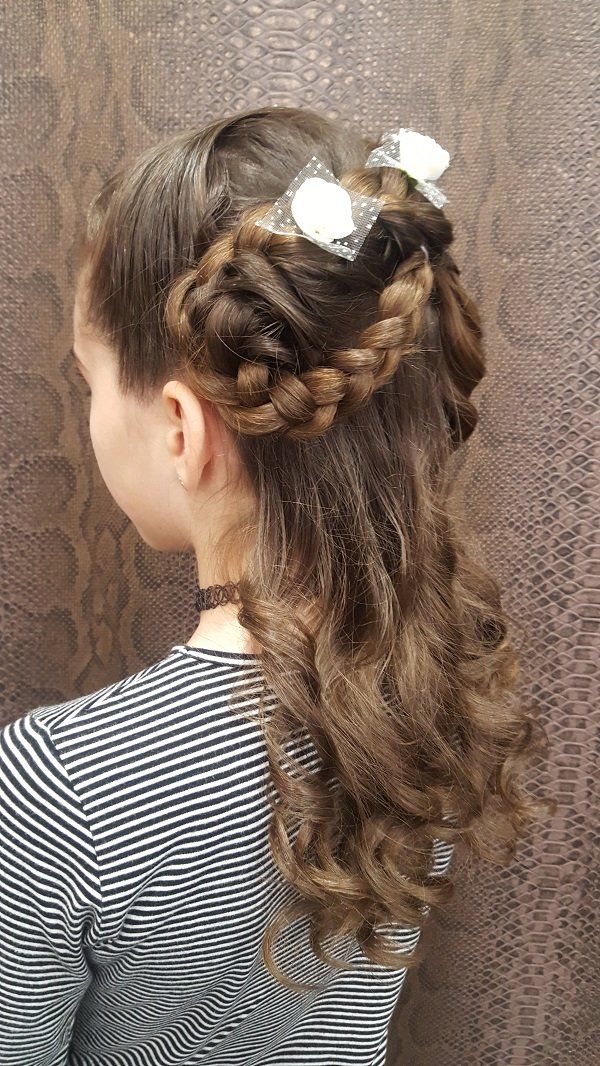 Una niña lleva una cola de caballo con una trenza y un lazo.