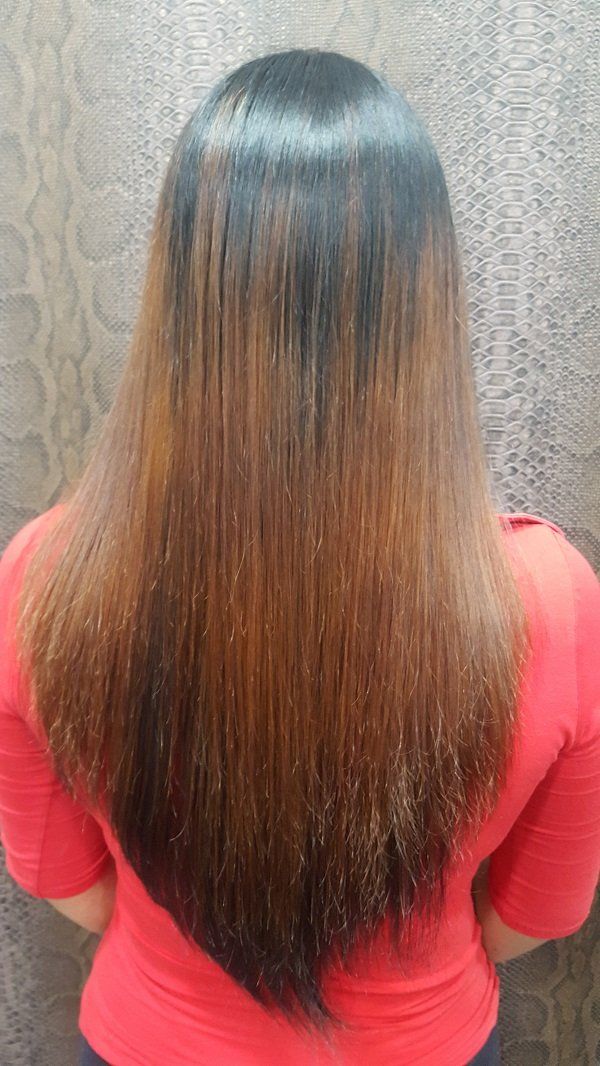 La parte posterior de la cabeza de una mujer con cabello largo y una camisa roja.