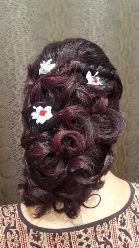 Una mujer lleva el pelo recogido en un moño con flores.