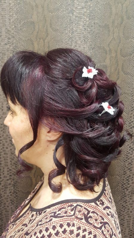 Una mujer lleva el pelo recogido en un moño con flores.