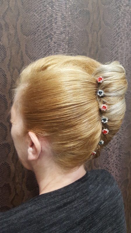 Una mujer lleva un moño con una horquilla en el pelo.