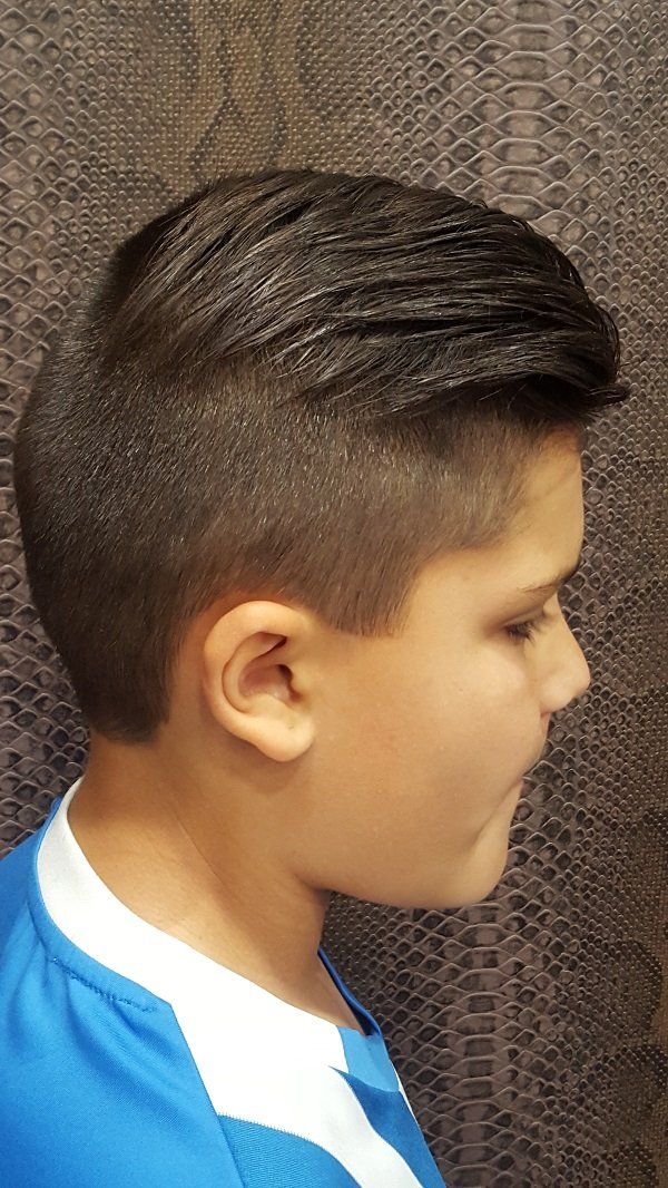 Un niño pequeño con la cabeza rapada lleva una camisa azul.