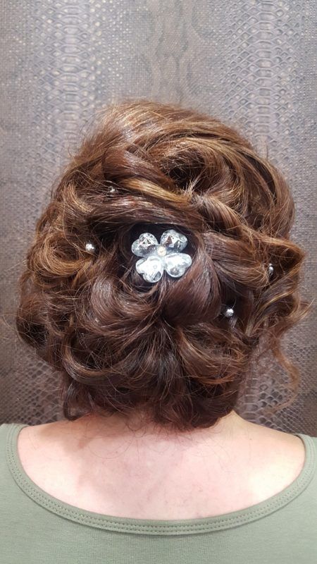 La parte posterior de la cabeza de una mujer con un moño y una flor en el pelo.