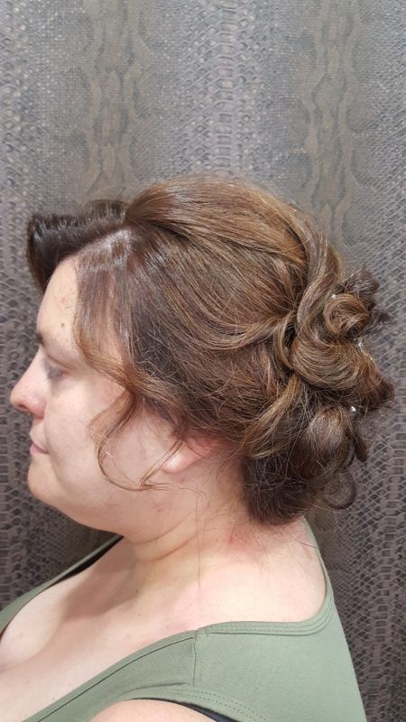 Una mujer con el pelo recogido en un moño lleva una camiseta verde sin mangas.