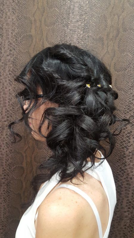 Una mujer con cabello largo y negro lleva una camiseta blanca sin mangas.