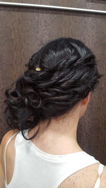 La espalda de una mujer que lleva una camiseta blanca sin mangas y el pelo recogido en un moño.