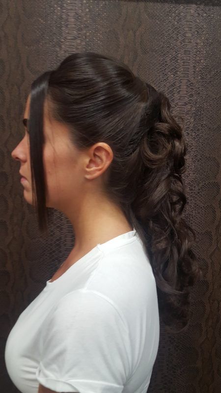 La mujer lleva una camisa blanca y tiene el cabello recogido en una cola de caballo.