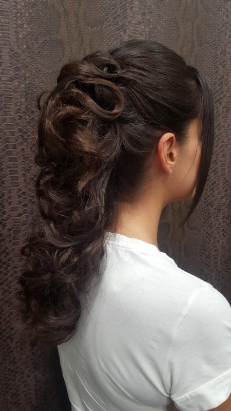 La mujer lleva una camisa blanca y tiene el cabello recogido en una cola de caballo.