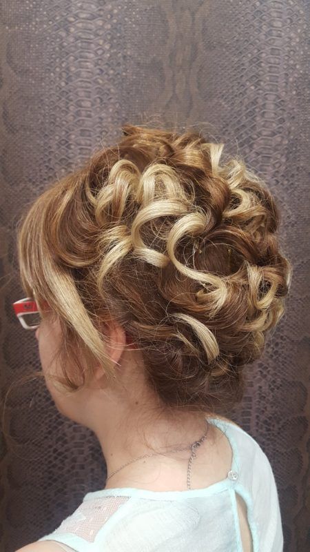 Una mujer lleva gafas y tiene el pelo recogido en un moño.