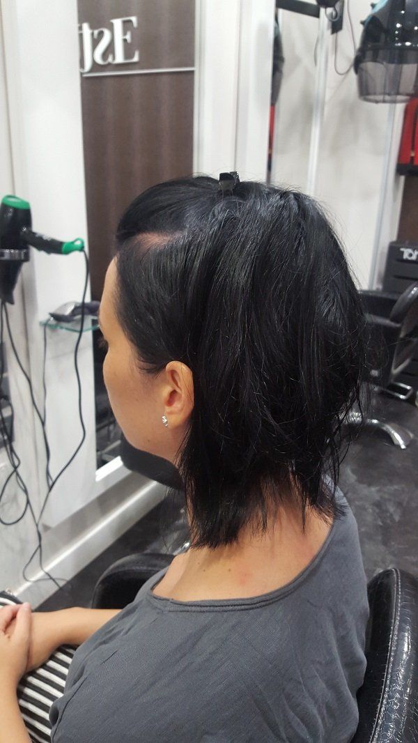 Una mujer se está cortando el pelo en una peluquería.