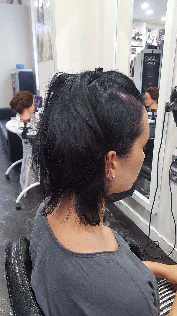 Una mujer se está peinando en un salón.