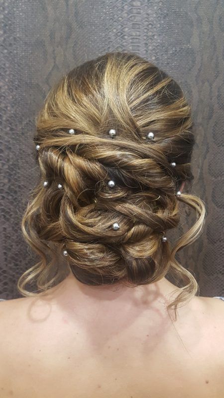 Una mujer lleva el pelo recogido en un moño con perlas.