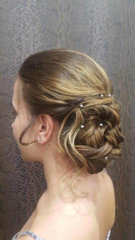 Una mujer lleva el pelo recogido en un moño con perlas.