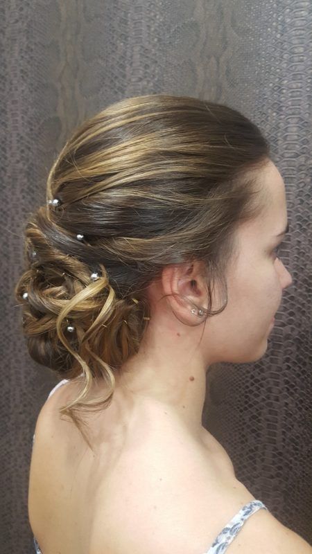 Una mujer lleva el pelo recogido en un moño con perlas.