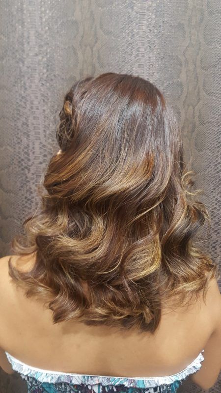 La parte posterior de la cabeza de una mujer con el cabello recogido mitad arriba y mitad abajo.