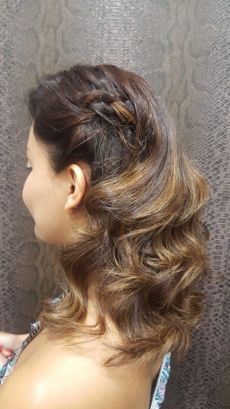 Una mujer lleva el cabello recogido en una trenza.