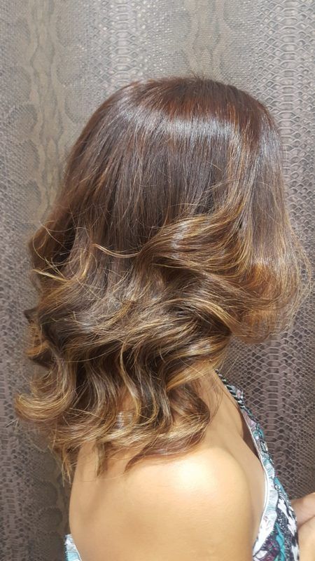 Una mujer con cabello castaño corto está parada frente a una pared.