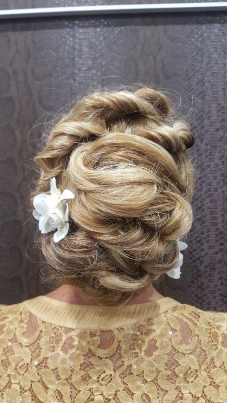 La parte posterior de la cabeza de una mujer con un moño y una flor en el pelo.