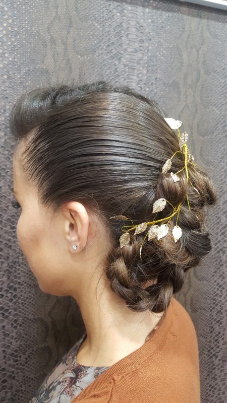 Una mujer lleva el pelo recogido en un moño con flores.