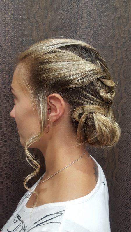 Una mujer lleva una camisa blanca y tiene el pelo recogido en un moño.