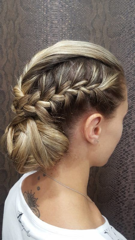 Una mujer lleva el pelo recogido en un moño trenzado.