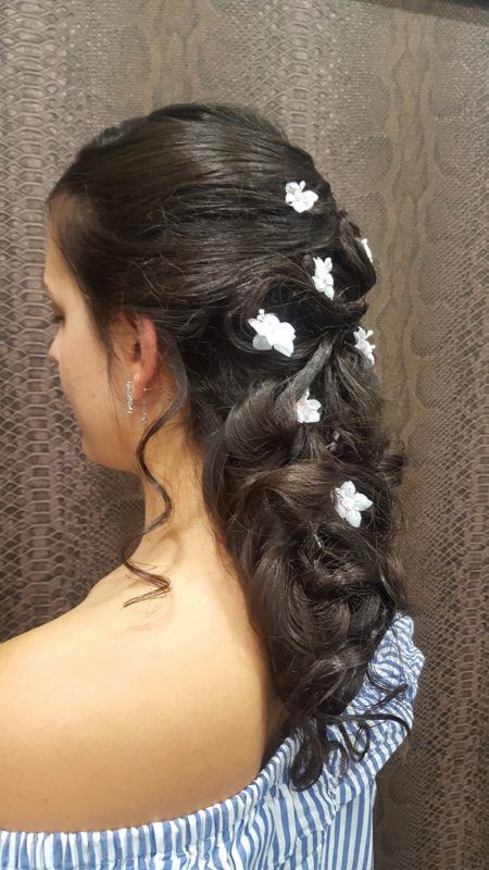 Una mujer con cabello largo y flores blancas en el cabello.