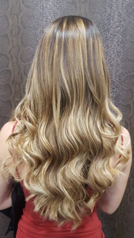 Una mujer con cabello largo y rubio lleva un vestido rojo.