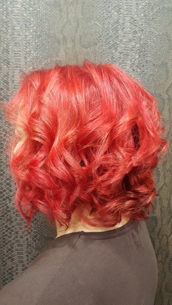 Una mujer con cabello rojo y rizado está sentada en un sofá.